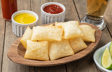 Pastel, typical brazilian finger food over wooden table