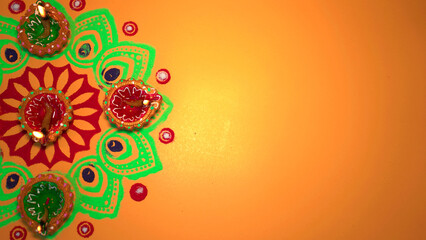 Oil lamps lit on colorful rangoli during diwali celebration. Happy Diwali - Clay Diya lamps lit...