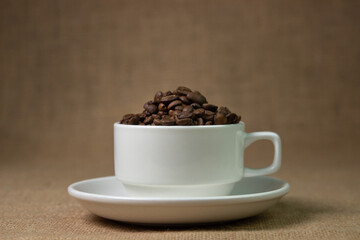 White cup full of coffee beans. natural coffee drink