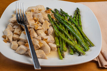 chicken bites top with sautyeed onions and asparagus