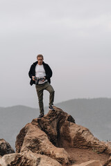 Man is standing on a high viewpoint with video camera