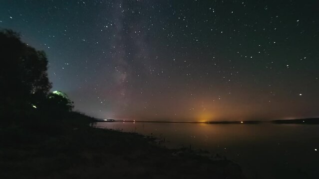 Night Sky Timelapse With Flat Calm Lake. Milky Way Is Visible In Starry Sky. Space, Galaxy, Earth Rotating Concept