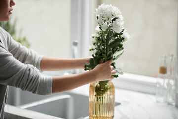 Woman Putting Flowers in Vase