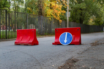 Roadworks warning traffic signs of construction work on city street and slowly moving cars