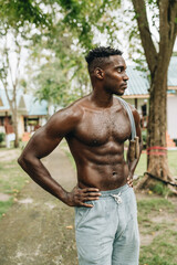 Black young sportsman resting while working out with jumping rope outdoors