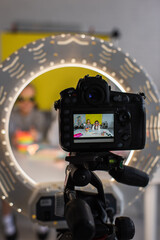 selective focus of video camera in circle lamp with preteen bloggers in trendy sunglasses on screen