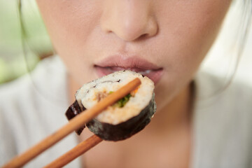 Woman Putting Sushi in Mouth