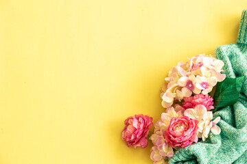Spring background with flowers and knitted element, flat lay.