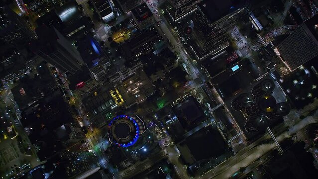 Overhead Aerial view of Downtown Los Angeles at Night. Blurred brands and Logos. Beautiful look down on Big City Street next to Skyscrapers.  Shot on helicopter in 8K.