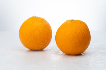 Two whole oranges on a white background