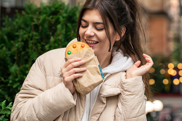 Attractive young woman with a beautiful gingerbread on a walk.