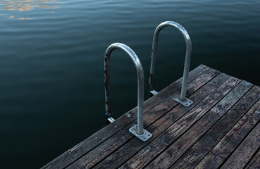 Wooden boards and water, masonry on the lake close-up.