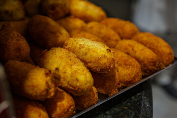 Crocchè di patate fritti napoletani con mozzarella e salame tenuti al caldo vicino al forno a legna