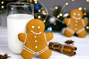 A traditional Christmas treat gingerbread man and glass of milk on the table at the kitchen. Close-up.