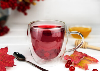 Vitamin tea from viburnum in the cup. Seasonal healthy drink. Close-up. Selective focus.
