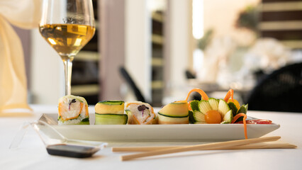 Beautiful served vegetarian sushi rolls on a plate. With natural vegetables and sauce. Black background
