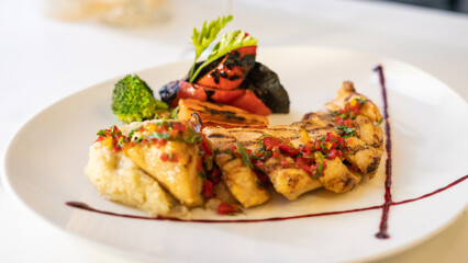 grilled fish with grilled vegetables and sause. black background