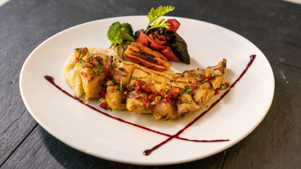 grilled fish with grilled vegetables and sause. black background
