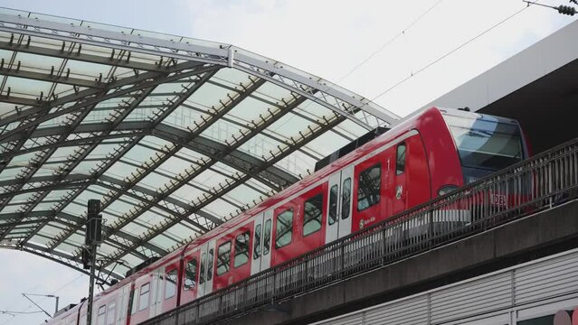 SPNV-Nord passenger rail transport train at Koln, Cologne Hbf (Hauptbahnhof) central train station. Red DB (Deutsche Bahn) train, slow motion