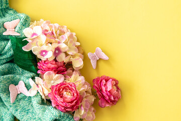 Spring background with flowers and knitted element, flat lay.