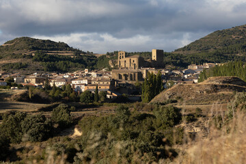 Obraz premium View of the town and small village of Luesia skyline, with its small stone houses, and the characteristic church San Salvador, Aragon, Spain