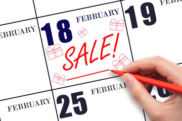 Hand writing text SALE and drawing gift boxes on calendar date February 18. Shopping Reminder