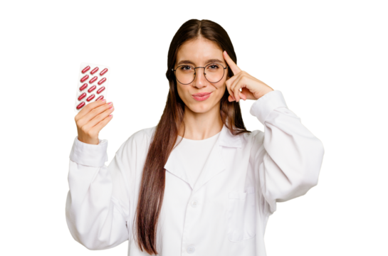 Young pharmacist woman holding a tablet of pills isolated pointing temple with finger, thinking, focused on a task. - Powered by Adobe