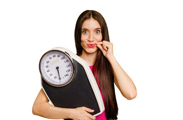 Young caucasian woman holding a scale isolated with fingers on lips keeping a secret.