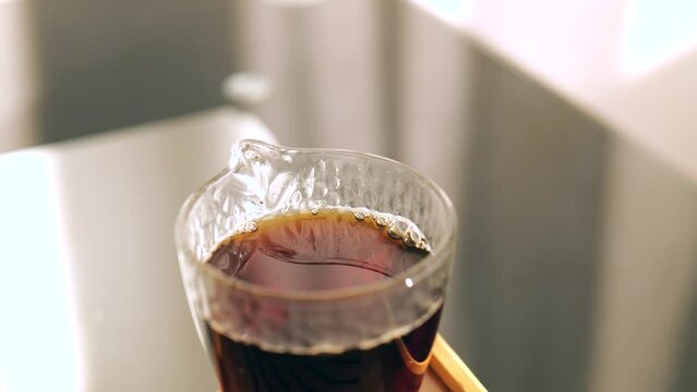 Strong dark Pu erh tea brewed in a special glass bowl. Chinese tea ceremony. 4k. Slow Motion