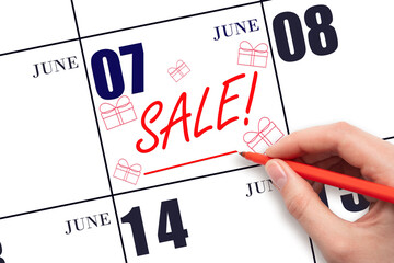 Hand writing text SALE and drawing gift boxes on calendar date June 7. Shopping Reminder