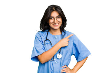 Young nurse Indian woman isolated smiling and pointing aside, showing something at blank space.