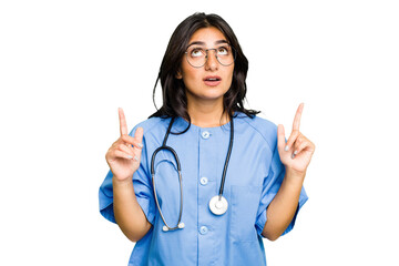 Young nurse Indian woman isolated pointing upside with opened mouth.