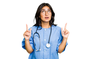 Young nurse Indian woman isolated pointing upside with opened mouth.