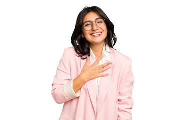 Young Indian business woman wearing a pink suit isolated laughs out loudly keeping hand on chest.