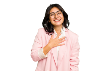 Young Indian business woman wearing a pink suit isolated laughs out loudly keeping hand on chest.