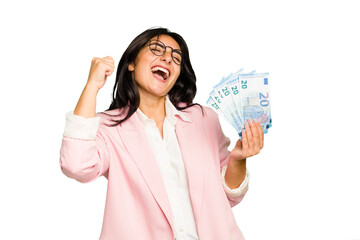 Young business Indian woman holding banknotes isolated raising fist after a victory, winner concept.