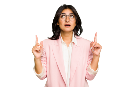 Young Indian business woman wearing a pink suit isolated pointing upside with opened mouth. - Powered by Adobe