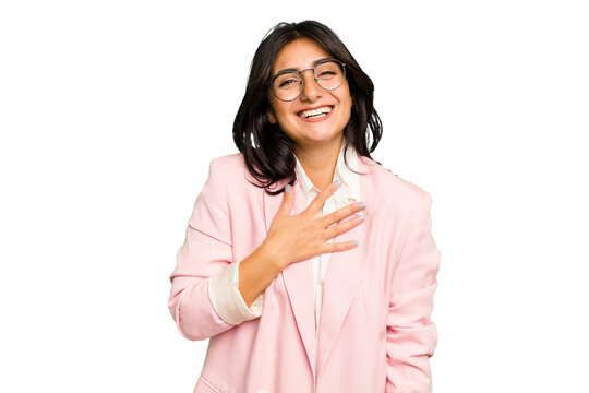 Young Indian business woman wearing a pink suit isolated laughs out loudly keeping hand on chest.