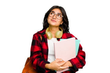 Young student Indian woman wearing headphones isolated dreaming of achieving goals and purposes