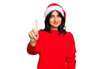 Young Indian woman celebrating Christmas wearing a santa hat isolated showing number one with finger.