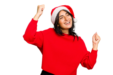 Young Indian woman celebrating Christmas wearing a santa hat isolated raising fist after a victory, winner concept.