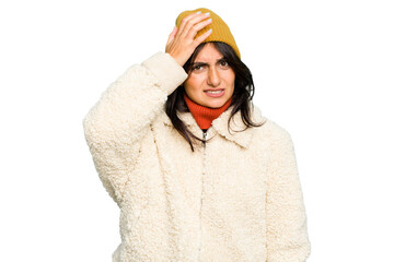Young Indian woman wearing winter jacket and a wool cap isolated being shocked, she has remembered important meeting.