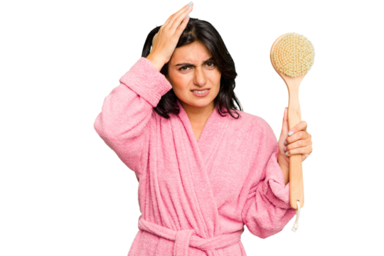 Young Indian woman in a bathrobe holding a back scratcher isolated being shocked, she has remembered important meeting.