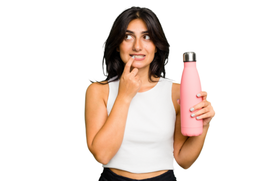 Young Indian woman holding a thermo isolated relaxed thinking about something looking at a copy space.