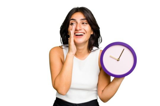 Young Indian woman holding a clock isolated is saying a secret hot braking news and looking aside