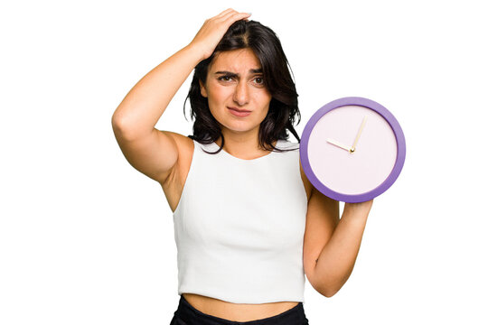 Young Indian woman holding a clock isolated being shocked, she has remembered important meeting.
