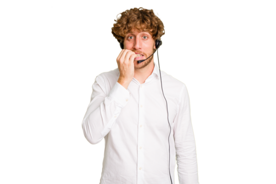 Telemarketer man working with a headset isolated on green chroma background biting fingernails, nervous and very anxious.
