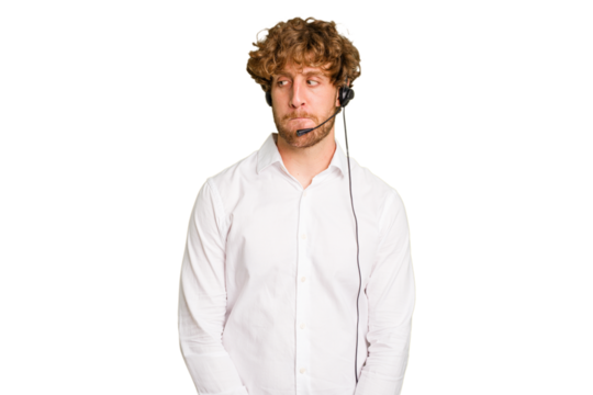 Telemarketer man working with a headset isolated on green chroma background confused, feels doubtful and unsure.