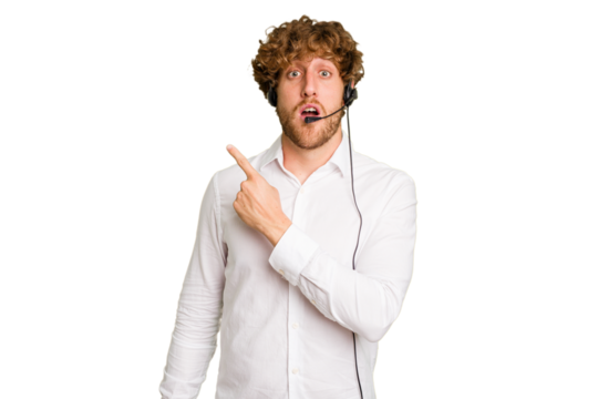 Telemarketer man working with a headset isolated on green chroma background pointing to the side