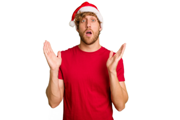 Young caucasian man wearing a Christmas Santa hat isolated on white background surprised and shocked.